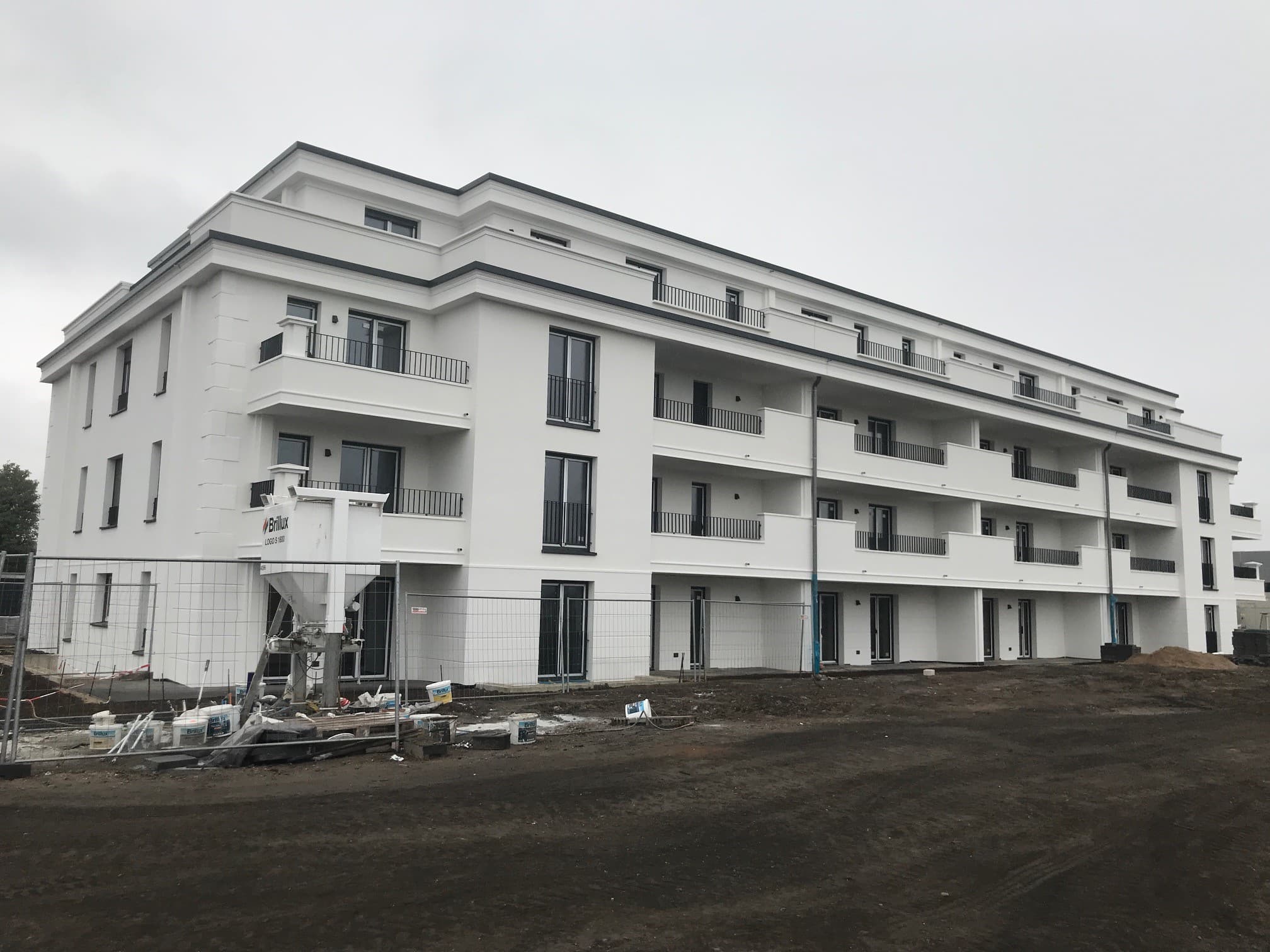 Mehrfamilienhaus im Bau mit frisch verputzter Fassade